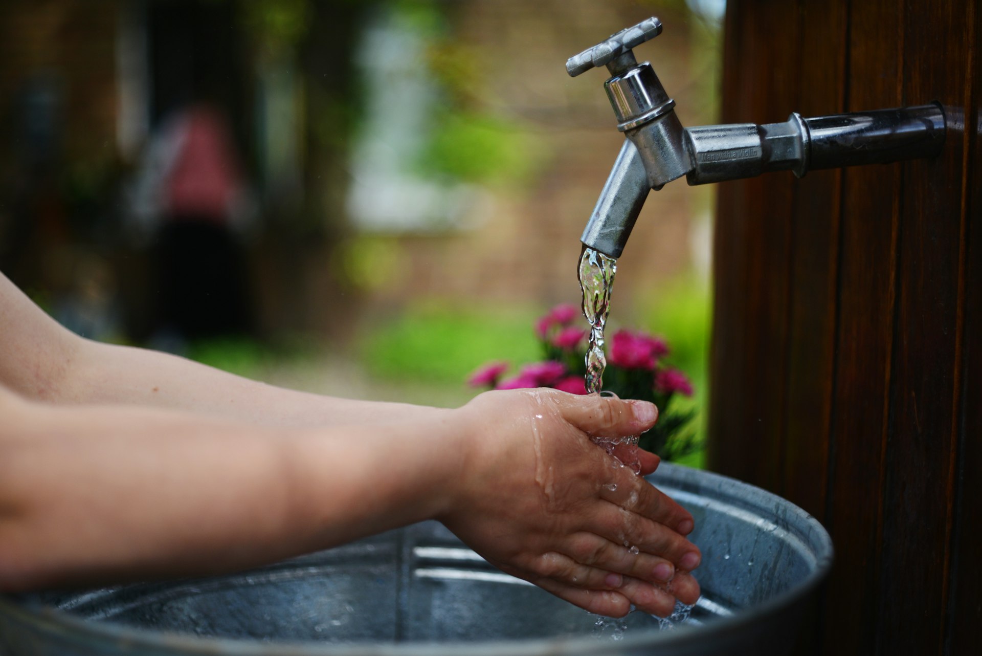 a person washing their hands under a faucet